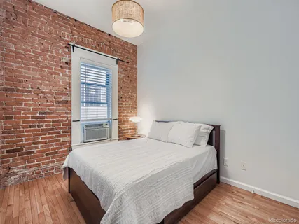 a bedroom with a bed and wooden floor