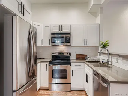 a kitchen with appliances a sink and cabinets