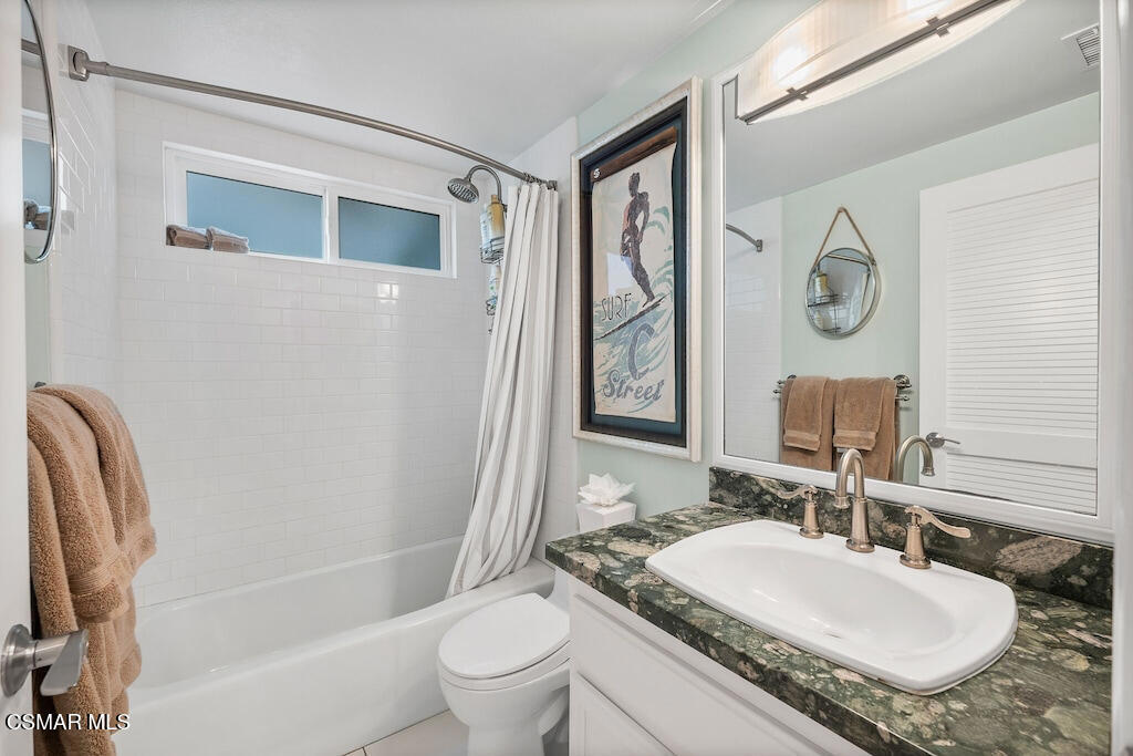 3237 Playa Court Oxnard, CA 93035 - Photo 12 of 48 a bathroom with a granite countertop sink toilet a mirror and shower