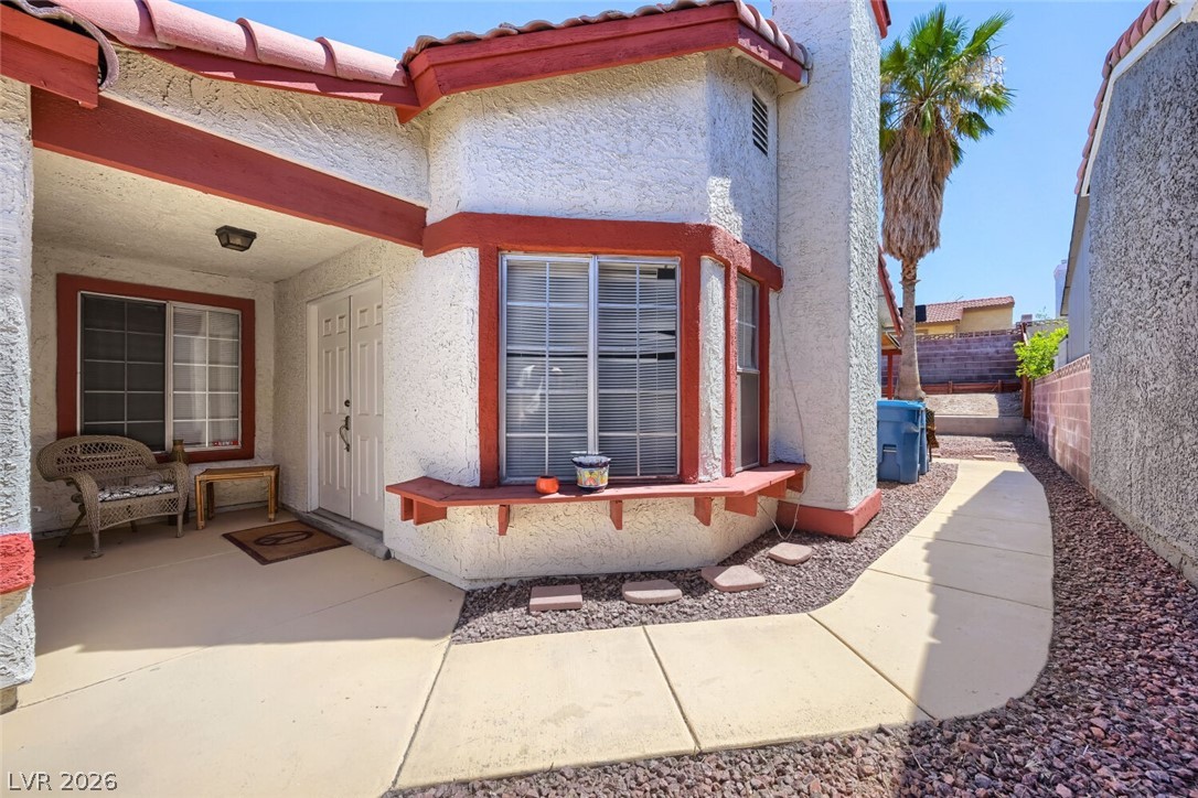 A well-maintained stucco exterior welcomes you with a covered front porch and vibrant trim.