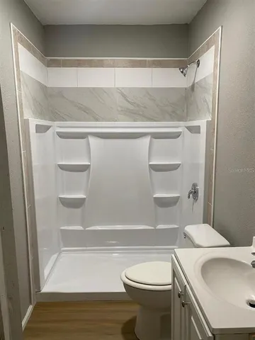 a bathroom with a sink a toilet and shower