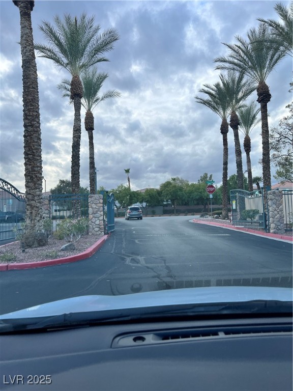 2152 Quarry Ridge Street, Unit 103 Las Vegas, NV 89117 - Photo 41 of 43 View of asphalt street featuring curbs, traffic signs, and a gated entry