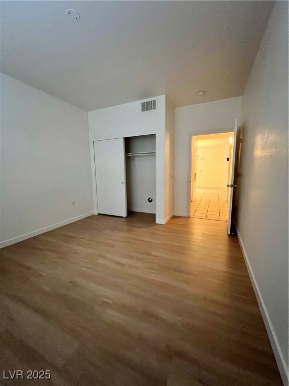 2152 Quarry Ridge Street, Unit 103 Las Vegas, NV 89117 - Photo 10 of 43 Unfurnished bedroom featuring wood finished floors and a closet