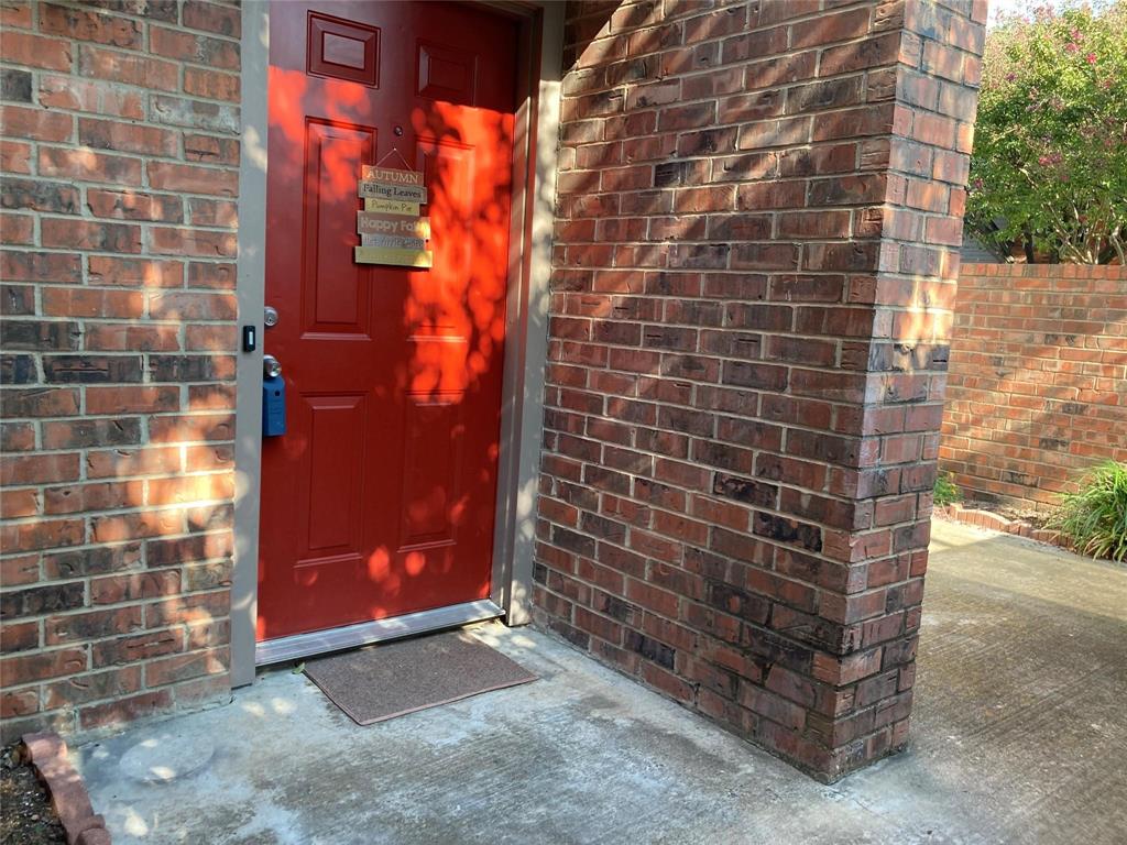 Doorway to property featuring brick siding
