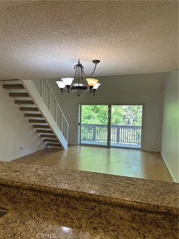 a view of an empty room stairs and a floor to ceiling window