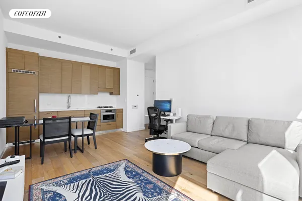 a living room with furniture a rug and a dining table with wooden floor