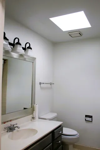 a bathroom with a sink toilet and mirror