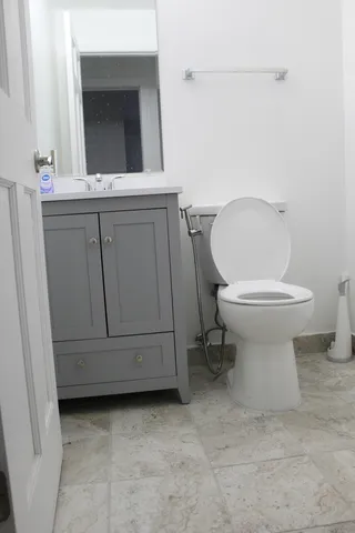 a bathroom with a toilet sink and mirror