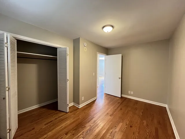 an empty room with wooden floor and closet