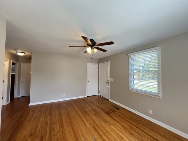 a view of a room with wooden floor and a ceiling fan