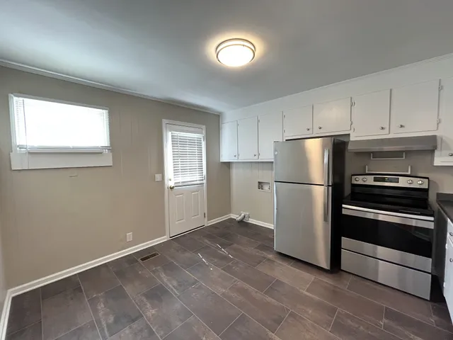 a kitchen with a refrigerator and a stove top oven