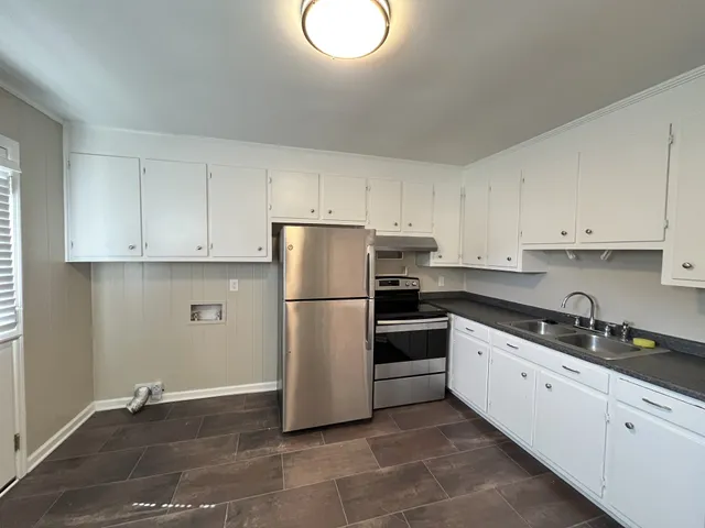 a kitchen with a refrigerator sink and cabinets