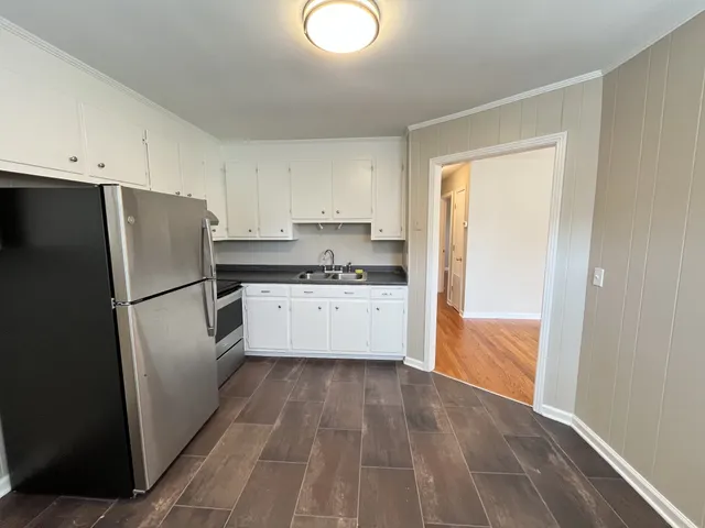 a kitchen with a refrigerator a sink and dishwasher with wooden floor
