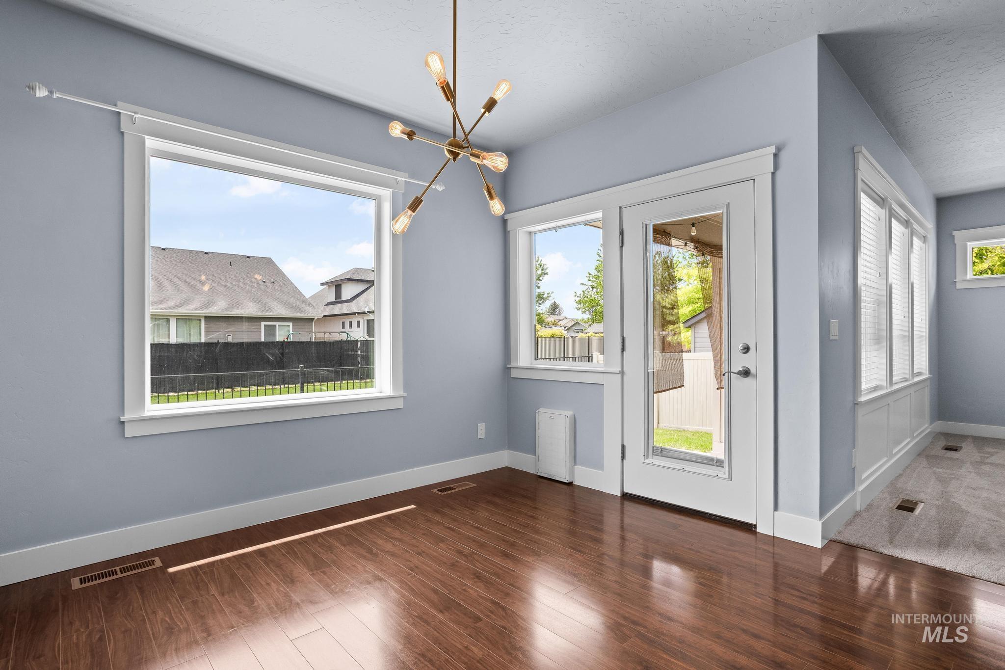 2681 East Rhyolite Court Nampa, ID 83686 - Photo 22 of 48 Spacious room with wood-finish flooring and a contemporary chandelier