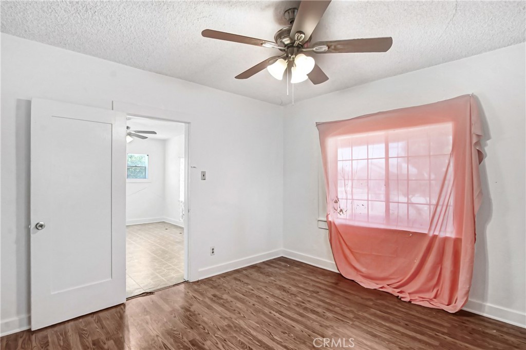 3463 Washington Street Riverside, CA 92504 - Photo 11 of 24 an empty room with wooden floor fan and windows
