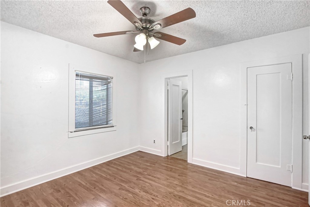 3463 Washington Street Riverside, CA 92504 - Photo 12 of 24 an empty room with wooden floor chandelier fan and windows