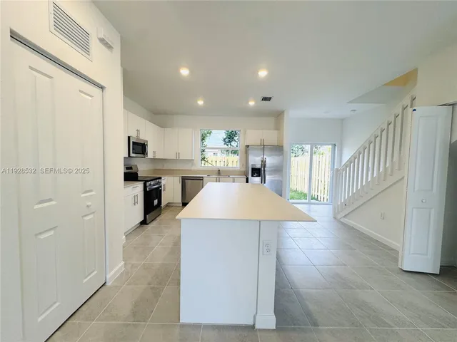 a kitchen with a refrigerator a stove and a cabinets
