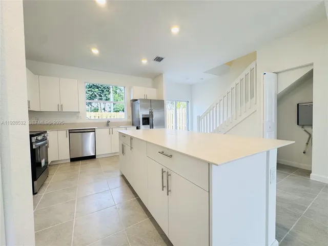 a kitchen with a sink stove and cabinets