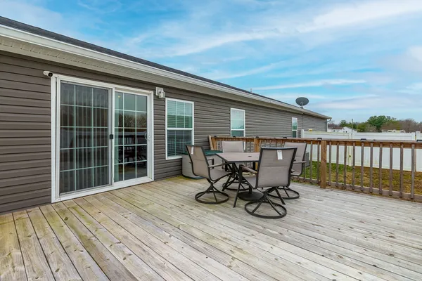 a view of a roof deck with table and chairs and wooden floor