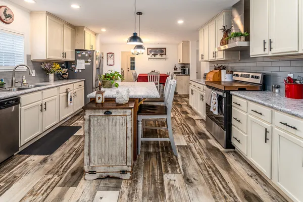 a kitchen with kitchen island granite countertop lots of counter top space and appliances