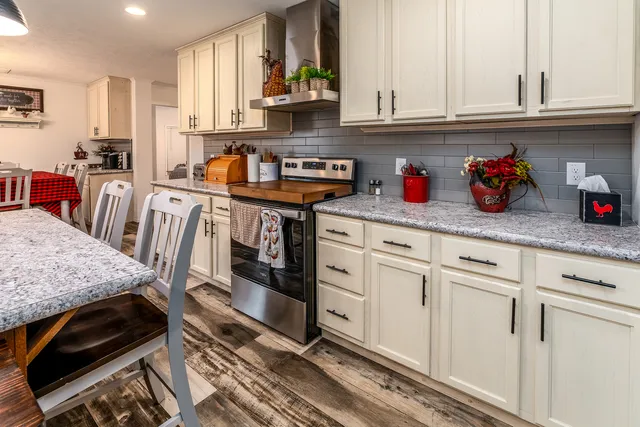 a kitchen with granite countertop a sink cabinets and stove