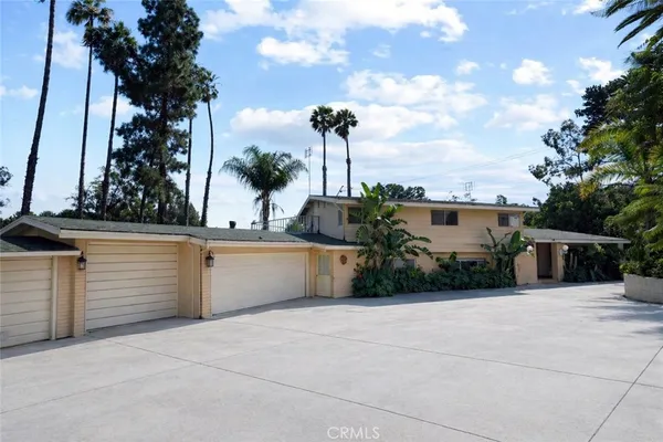 a front view of a house with a yard and trees
