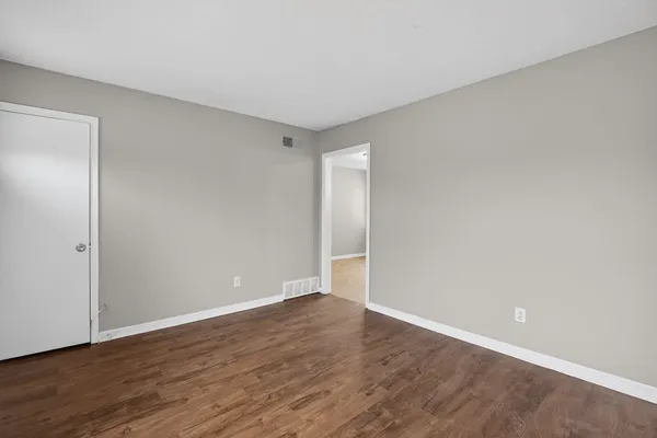 a view of an empty room with wooden floor