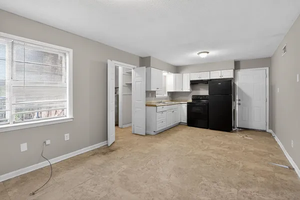 a kitchen with granite countertop white cabinets and a stove
