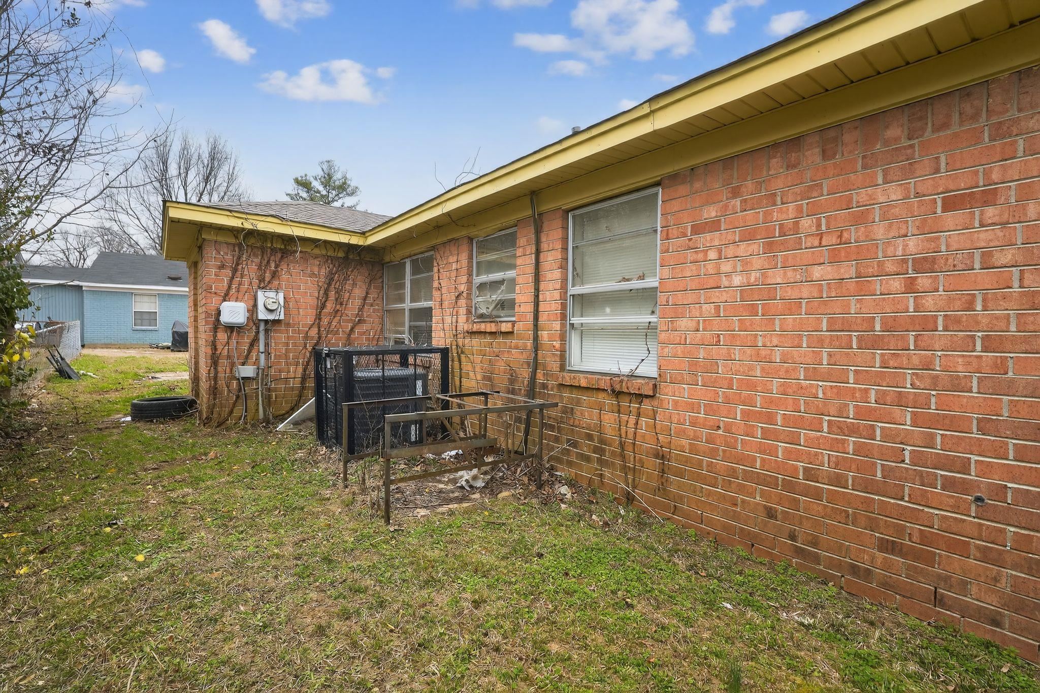 4094 Double Tree Street Memphis, TN 38109 - Photo 2 of 31 View of side of property with brick siding and a lawn