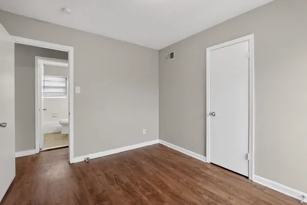 a view of an empty room with wooden floor