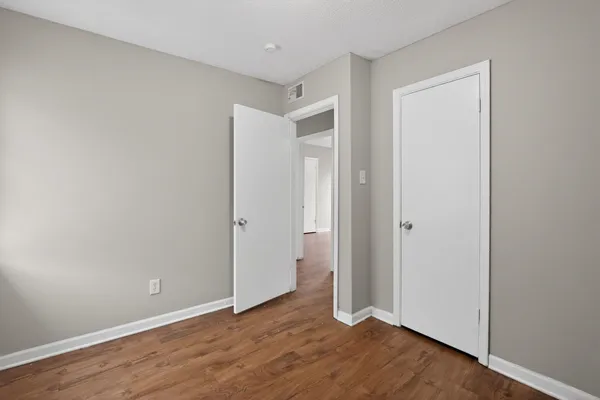 an empty room with windows and closet