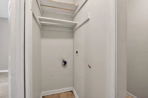 a view of storage and utility room with refrigerator and window