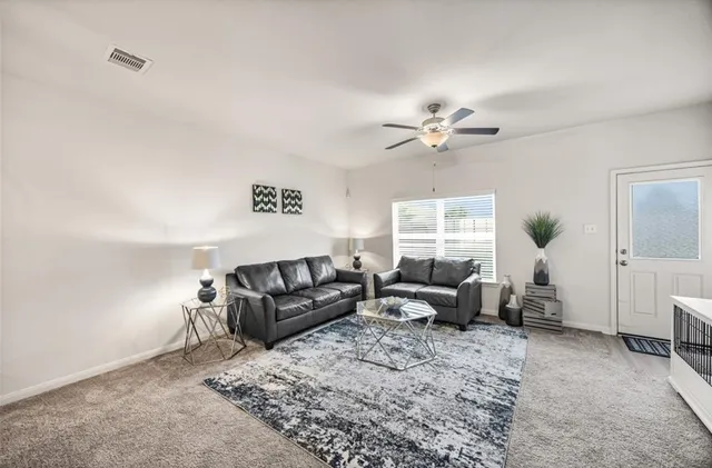 a living room with furniture chandelier and a window
