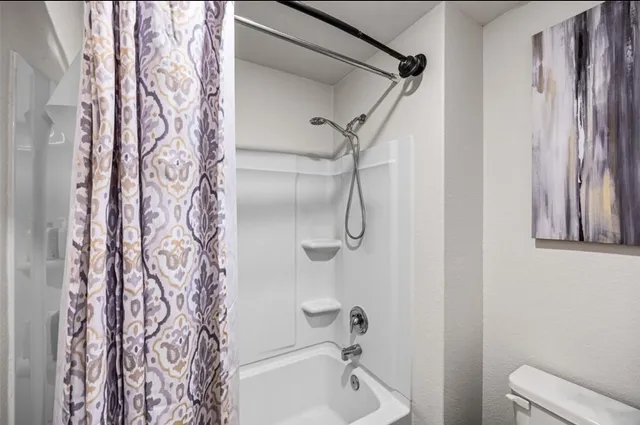 a bathroom with a shower curtain and a toilet