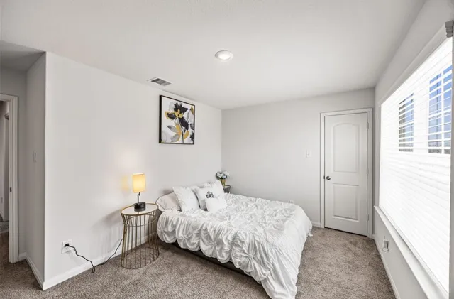 a bedroom with a bed and a window