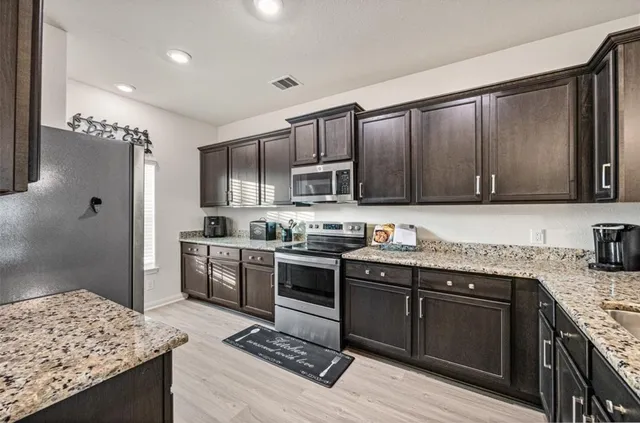 a kitchen with granite countertop stainless steel appliances and wooden cabinets