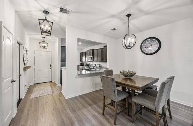 a view of a dining room with furniture wooden floor and a chandelier