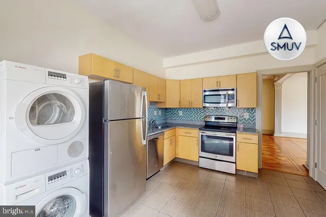 a kitchen with stainless steel appliances granite countertop a refrigerator a stove and a sink with dishwasher