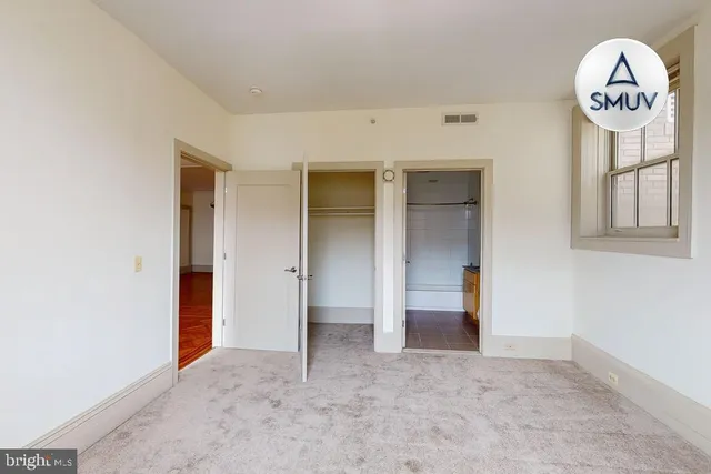 an empty room with a mirror and a window