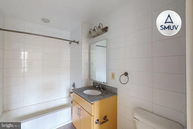 a bathroom with a granite countertop sink a toilet and a shower
