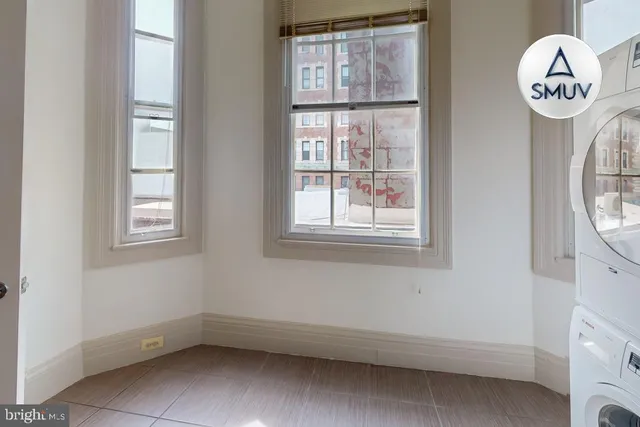 an empty room with a window and a mirror