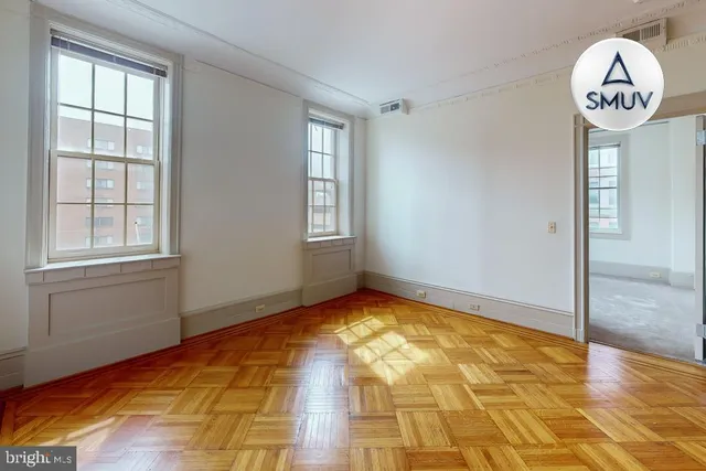 a view of an empty room with window and bathroom