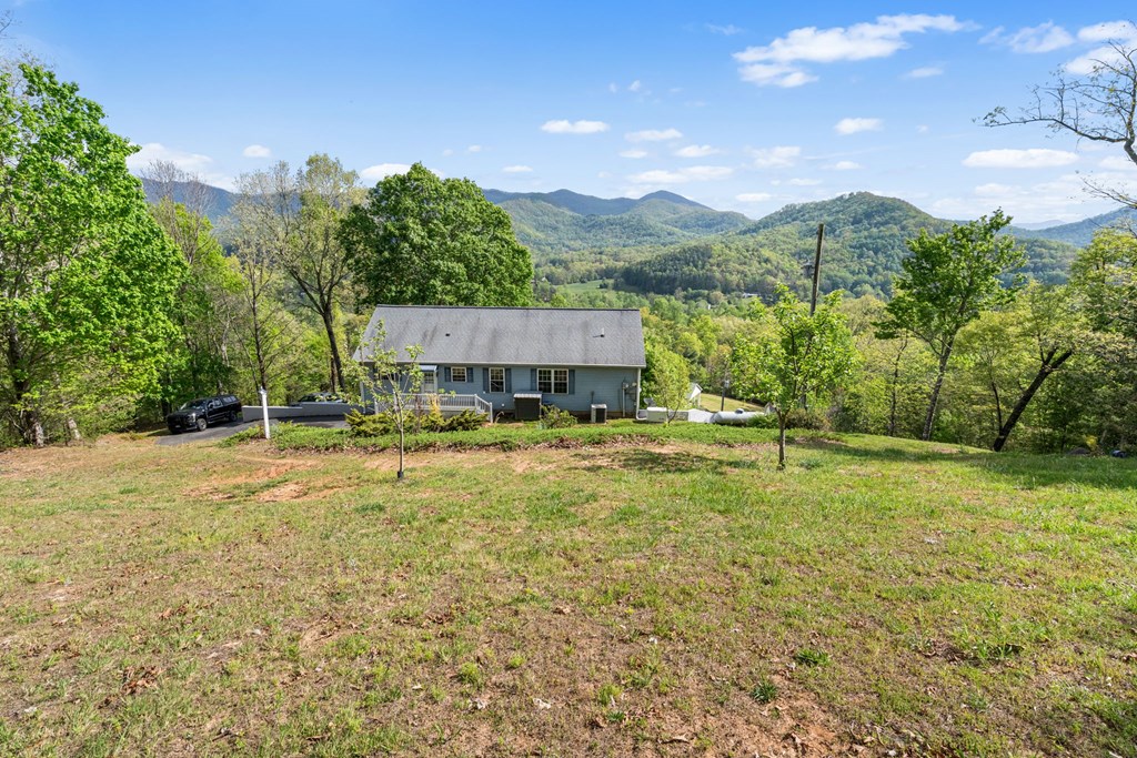 619 Pounding Mill Loop Hayesville, NC 28904 - Photo 18 of 54 a view of a house with a yard and a large tree