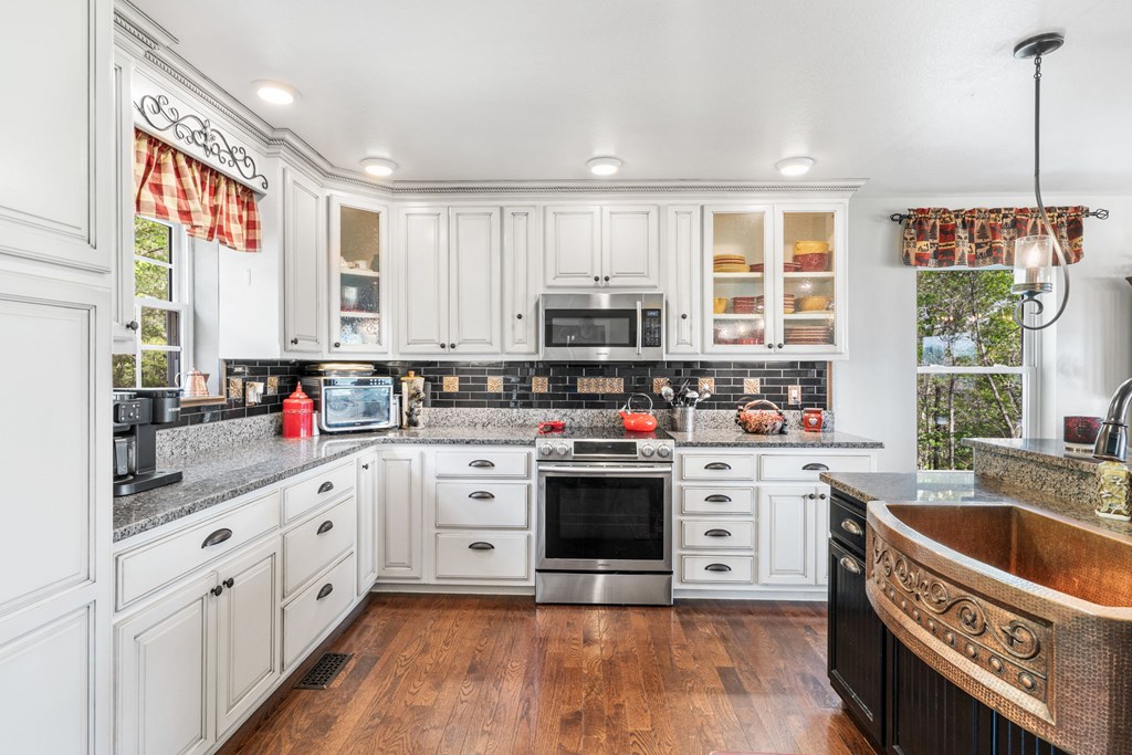 619 Pounding Mill Loop Hayesville, NC 28904 - Photo 21 of 54 a kitchen with stainless steel appliances granite countertop a stove a sink dishwasher a refrigerator and white cabinets with wooden floor