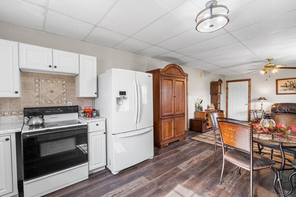 619 Pounding Mill Loop Hayesville, NC 28904 - Photo 50 of 54 a kitchen with stainless steel appliances a stove a refrigerator a dining table and chairs with wooden floor