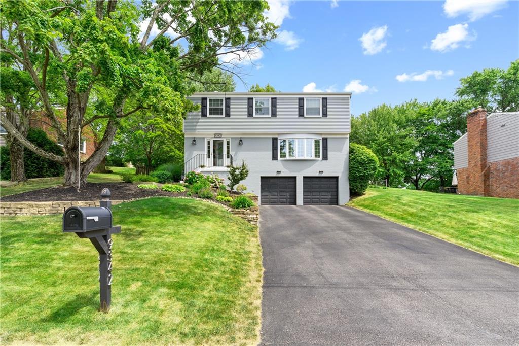 9342 Doral Drive Pittsburgh, PA 15237 - Photo 2 of 40 a front view of a house with a yard and trees
