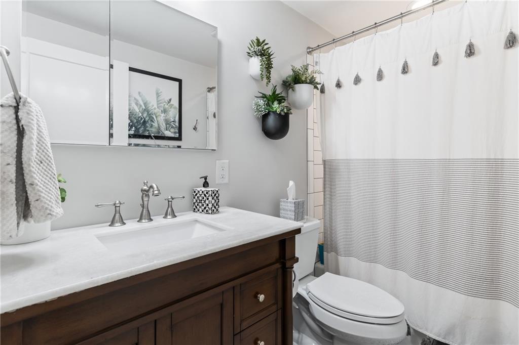 9342 Doral Drive Pittsburgh, PA 15237 - Photo 28 of 40 a bathroom with a sink a toilet and shower curtain