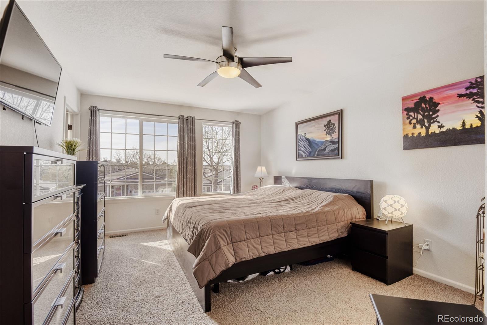 9649 Adelaide Circle Highlands Ranch, CO 80130 - Photo 15 of 32 a bedroom with a bed dresser and a window
