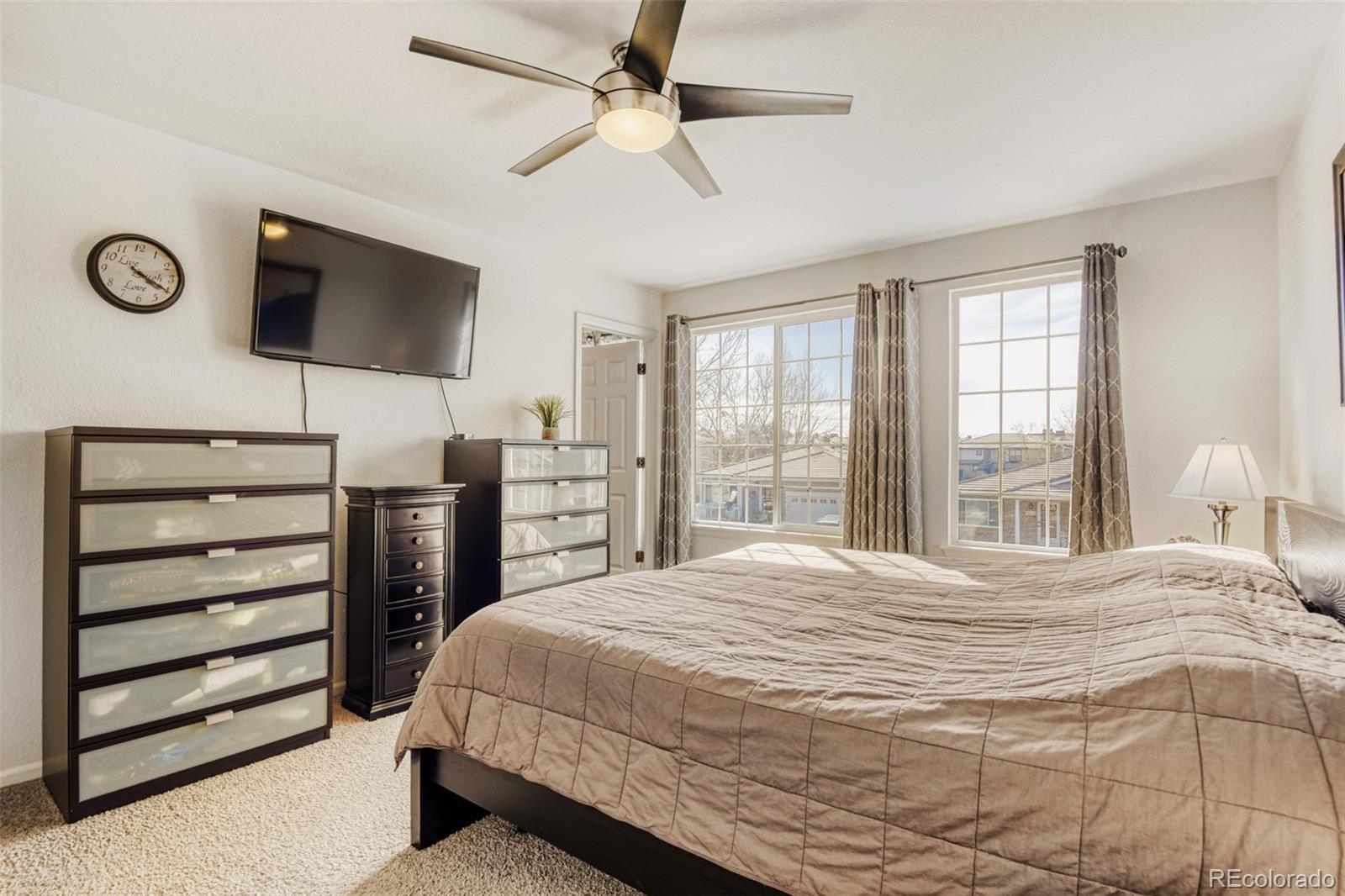 9649 Adelaide Circle Highlands Ranch, CO 80130 - Photo 16 of 32 a bedroom with a bed and a flat screen tv