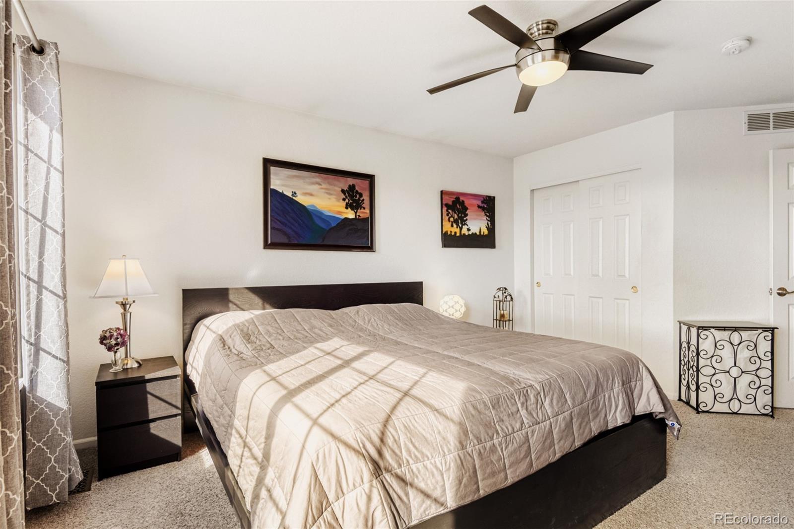 9649 Adelaide Circle Highlands Ranch, CO 80130 - Photo 17 of 32 a bedroom with a large bed and a chandelier